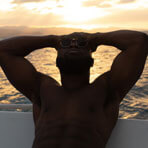 A man relaxes on a boat at sunset.